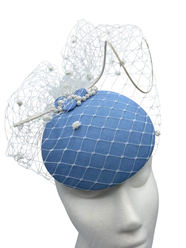 Stunning cornflower blue headpiece with white pom pom veiling overlay.